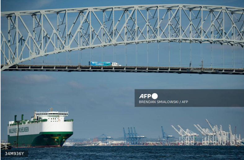 A cargo ship passes below the Francis Scott Key Bridge while leaving the Port of Baltimore October 14, 2021, in Baltimore, Maryland.